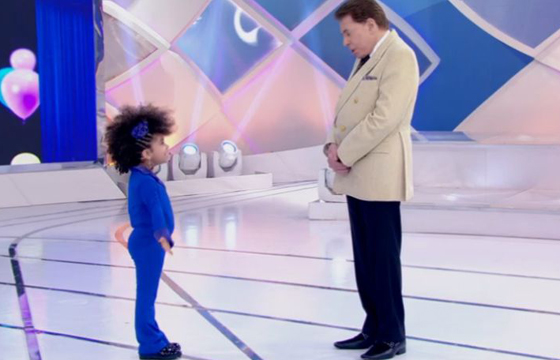 Silvio Santos recebeu a dançarina mirim Elis e fez comentários sobre o cabelo da garota (Reprodução/ SBT)