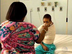 Mãe de Jeferson sá água ao garoto que permanece internado no Hospital das Clínicas. (Foto: Imagens / Tv Bahia)